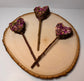 Heart-shaped rabbit forage pops with dried rose petals, botanicals  and a peach wood chew stick handles displayed on natural wood slice