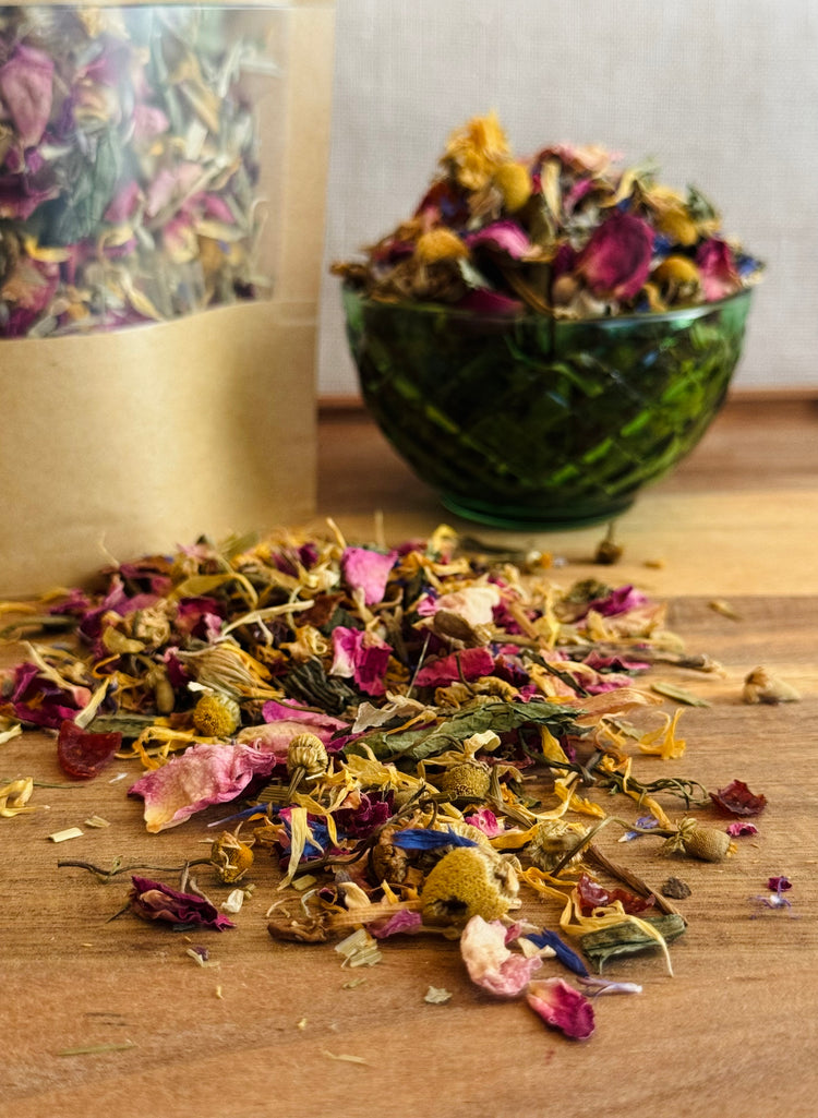 Dried  rabbit forage of flowers and herbs on a wooden surface with a green glass bowl and packaging in the background.