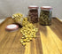  Yellow and green star-shaped rabbit treats spilling from clear apothecary jars onto wooden tray