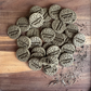 Small batch botanical digestive biscuits for rabbits arranged on a wooden board with scattered herbal blend
