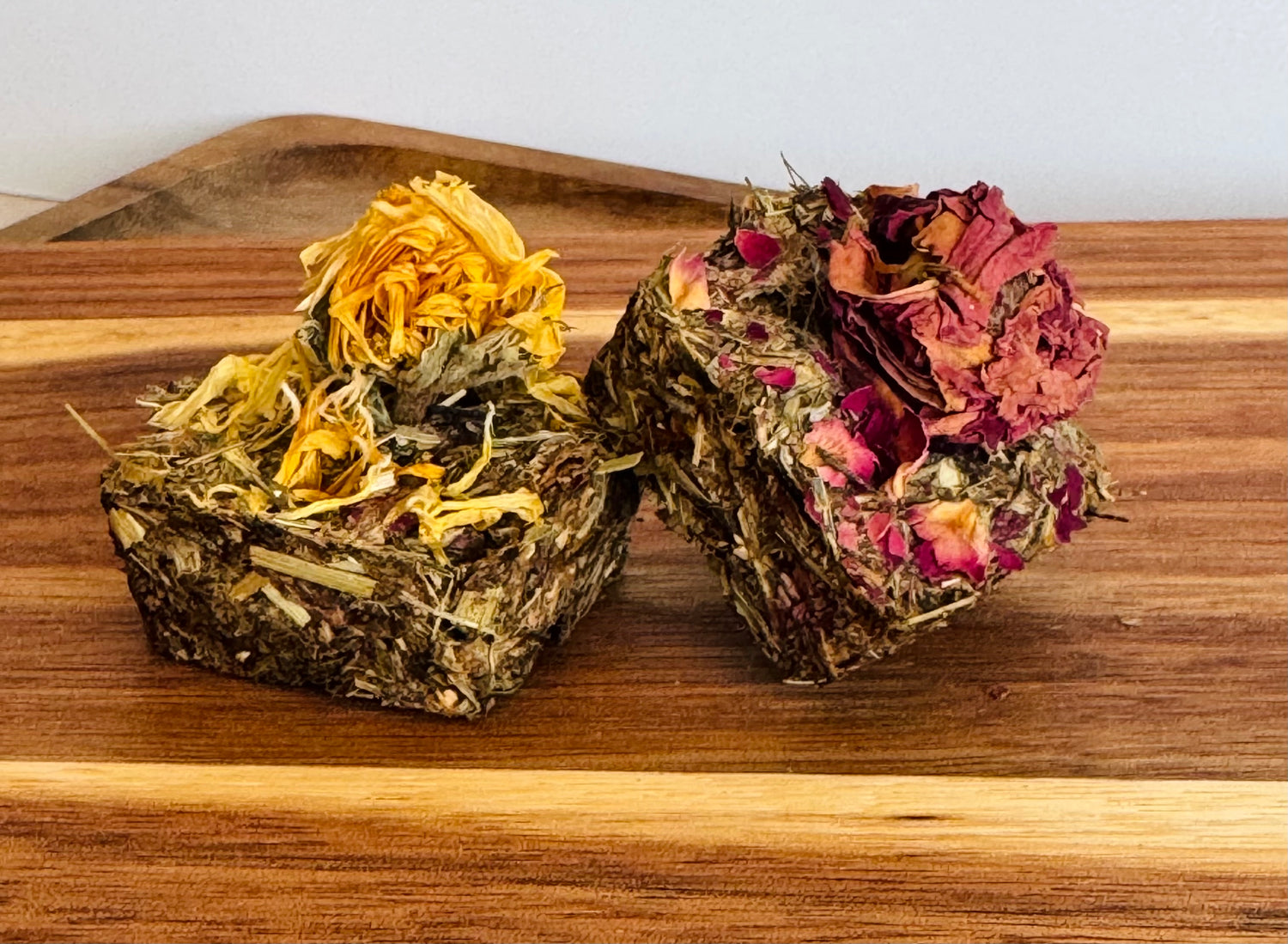 Botanical digestive forage bites for rabbits on a wooden board made with plantain, dandelion, and chamomile,calendula and rose buds