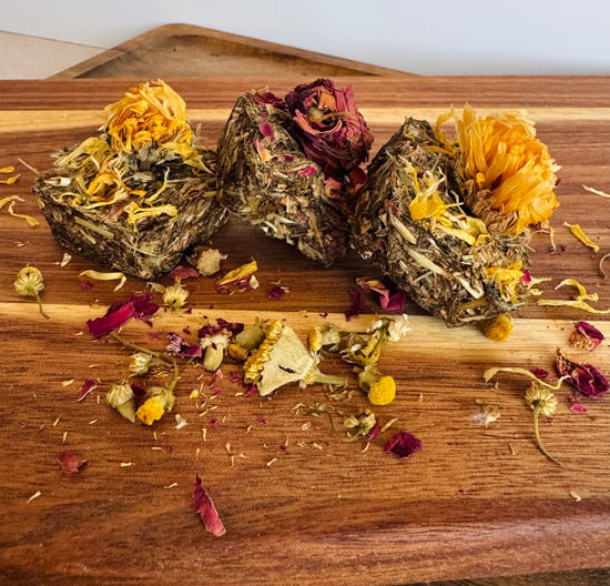 Botanical digestive forage bites for rabbits on a wooden board made with plantain, dandelion, and chamomile