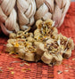 Flower-shaped herbal rabbit treats, displayed on a orange woven mat with a braided beige rope pumpkin in the background.
