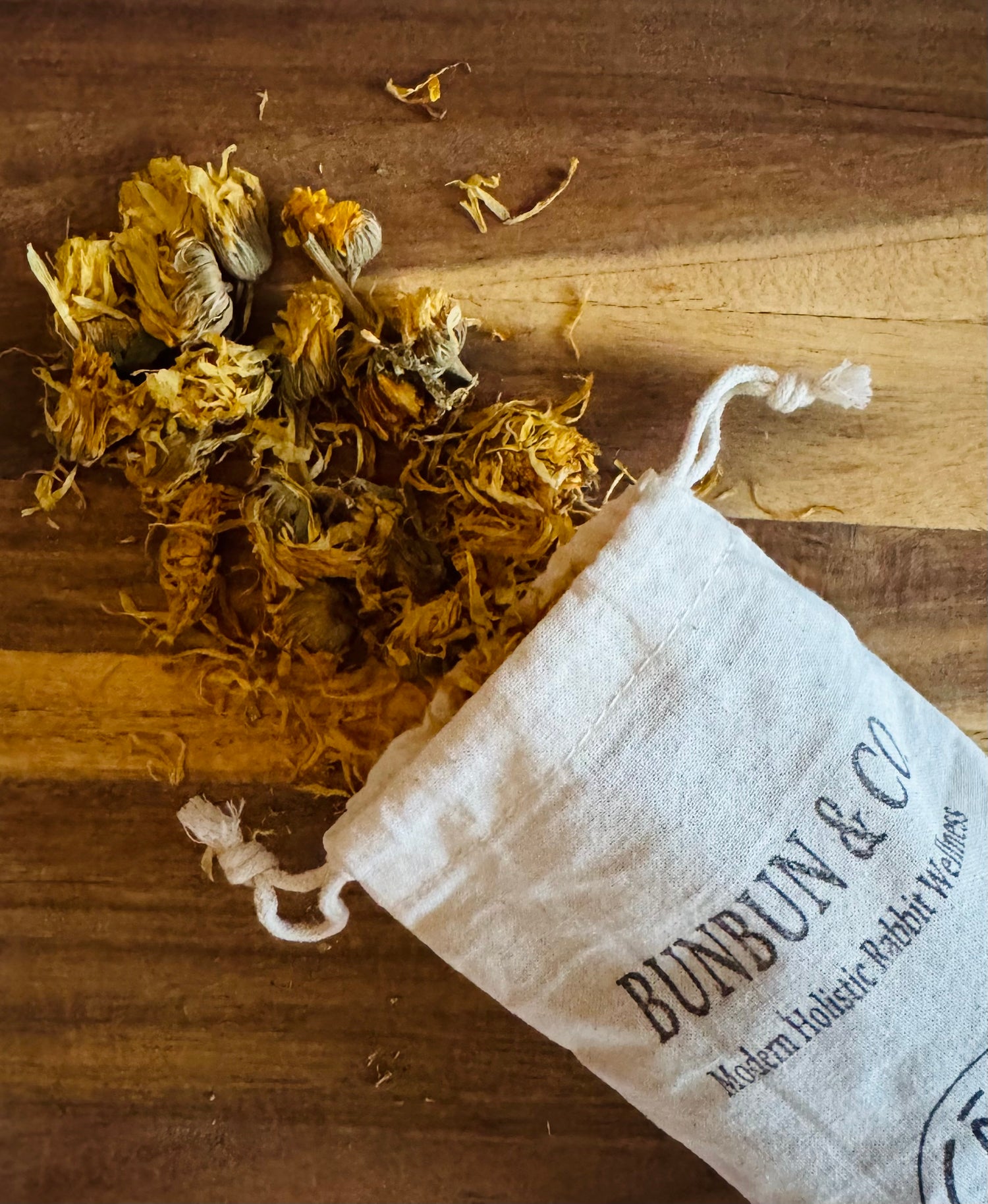 Dried  yellow marigold flowers spilling out of a white &