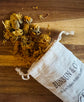 Dried  yellow marigold flowers spilling out of a white &
