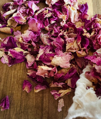 Dried  pink  rose petals on a wooden surface