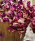Dried  pink  rose petals on a wooden surface