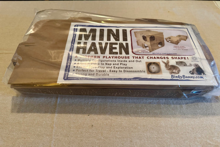 Mini Haven cardboard rabbit hide playhouse flat-pack kit in protective packaging with label instructions. Shown for shipment purposes.