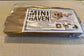 Mini Haven cardboard rabbit hide playhouse flat-pack kit in protective packaging with label instructions. Shown for shipment purposes.