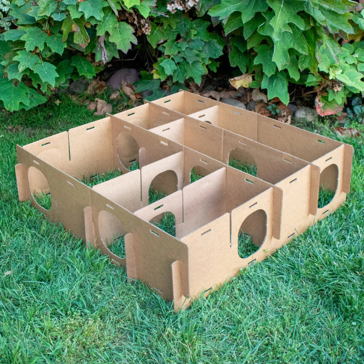 Large Maze Haven cardboard rabbit maze playhouse showing interior compartments and entrances on grass