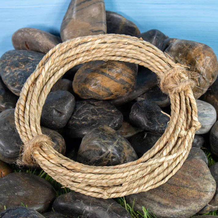 Natural seagrass rope ring chew toy for rabbits displayed on decorative rocks