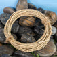 Natural seagrass rope ring chew toy for rabbits displayed on decorative rocks